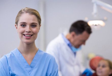 a closeup of a dental assistant smiling