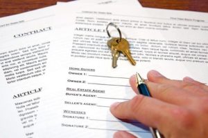 Picture of someone signing a real estate contract. 